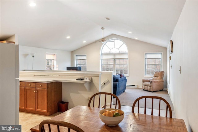 dining area with a ceiling fan, recessed lighting, a baseboard radiator, light colored carpet, and vaulted ceiling