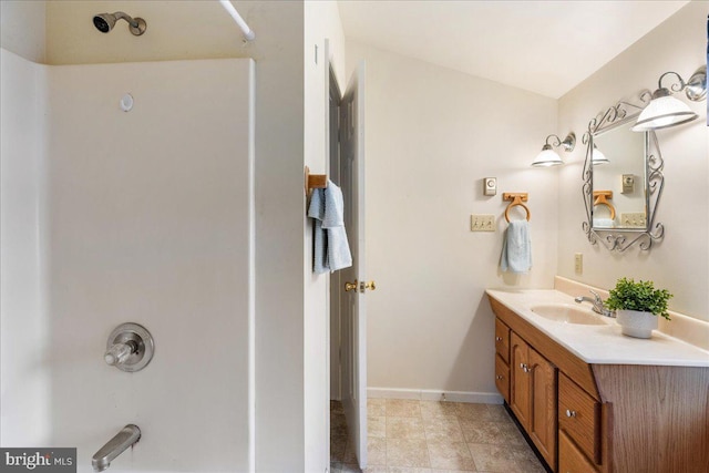 bathroom featuring vanity, bathing tub / shower combination, and baseboards