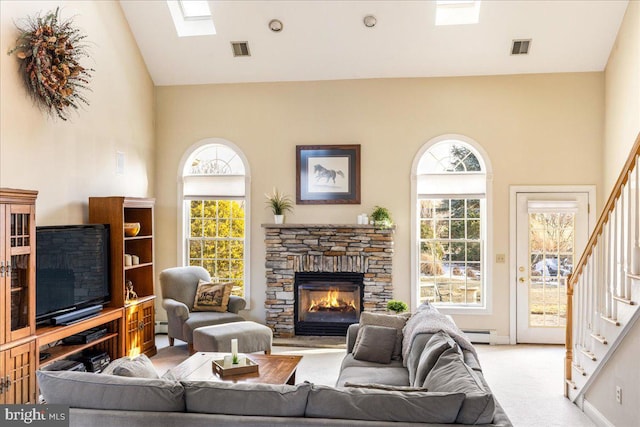 carpeted living area featuring visible vents, a stone fireplace, stairs, and a baseboard radiator