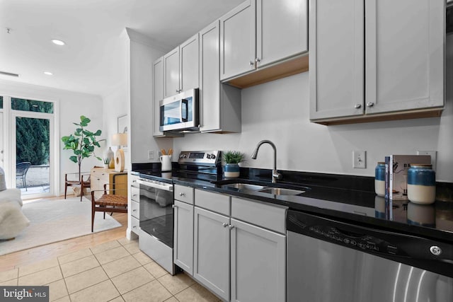 kitchen with stainless steel appliances, recessed lighting, ornamental molding, light tile patterned flooring, and a sink