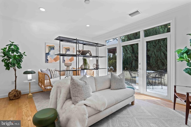 living area featuring baseboards, visible vents, ornamental molding, wood finished floors, and recessed lighting