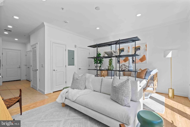 living area with ornamental molding, wood finished floors, electric panel, and recessed lighting