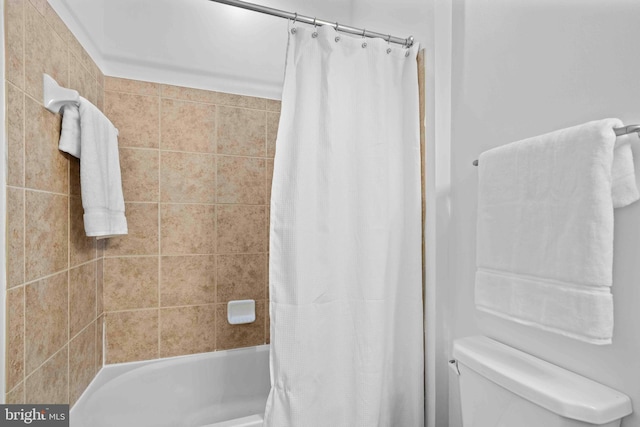 bathroom featuring shower / bath combo and toilet