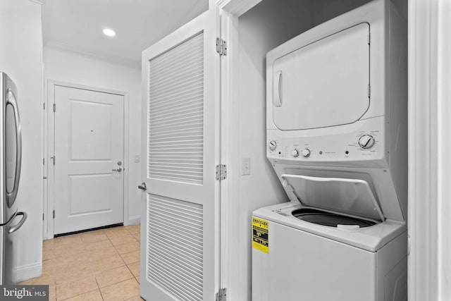 laundry room featuring light tile patterned floors, recessed lighting, laundry area, and stacked washer and clothes dryer