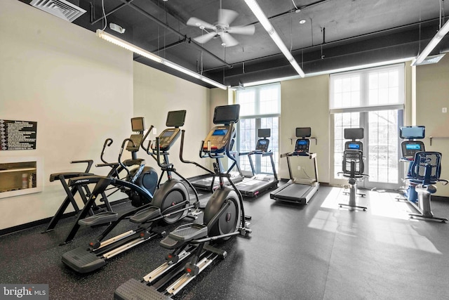 workout area featuring a towering ceiling, baseboards, visible vents, and ceiling fan