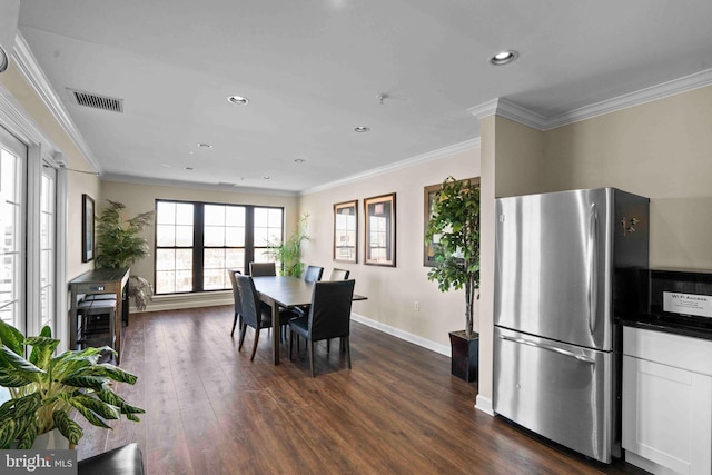 dining room with visible vents, dark wood finished floors, and crown molding