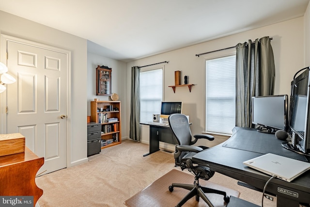 office area featuring light carpet and baseboards