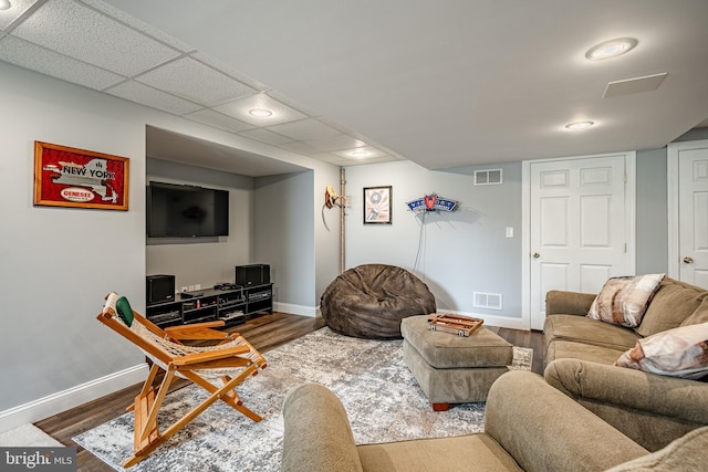 living area with baseboards, visible vents, and wood finished floors