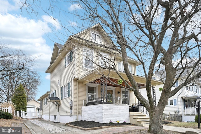 traditional style home with covered porch and fence