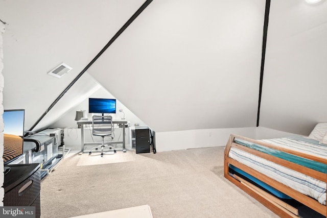 carpeted bedroom featuring vaulted ceiling and visible vents