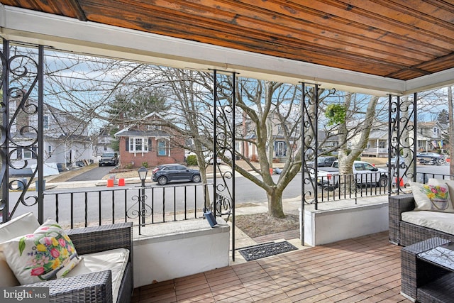 view of patio featuring a residential view, covered porch, outdoor lounge area, and a wooden deck