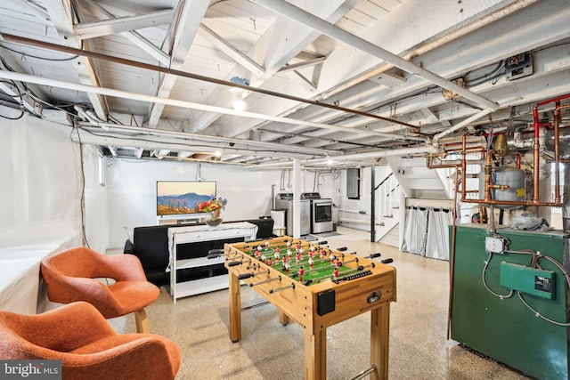 recreation room featuring electric panel, a heating unit, separate washer and dryer, and speckled floor