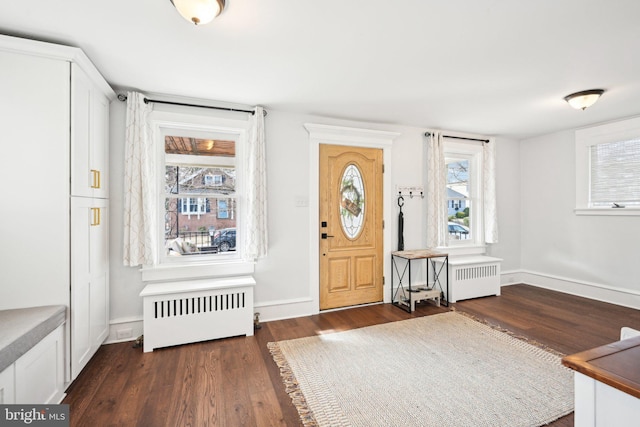 entryway with radiator, baseboards, and dark wood-type flooring