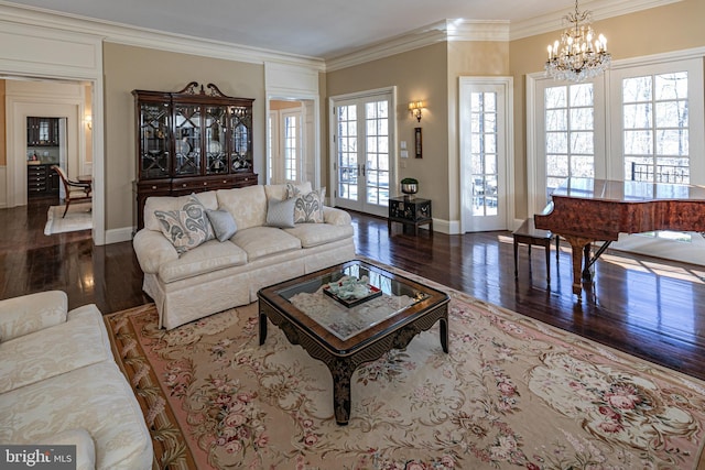 living room featuring french doors, a chandelier, crown molding, and wood finished floors