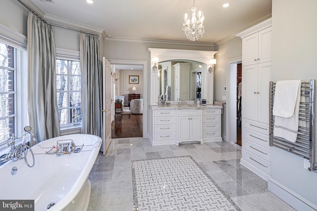 full bathroom with recessed lighting, a freestanding bath, ornamental molding, vanity, and a chandelier