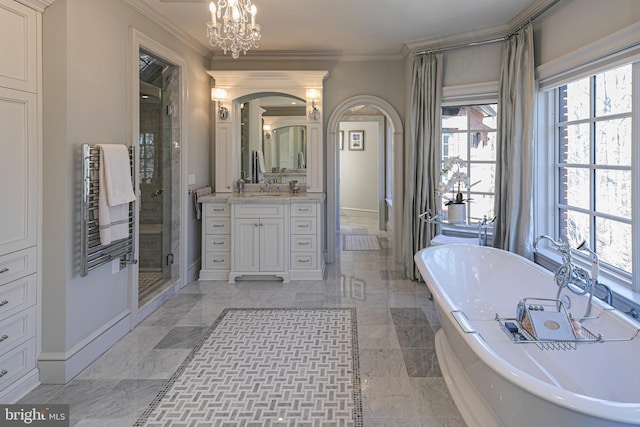 bathroom featuring a tub to relax in, crown molding, a shower stall, vanity, and baseboards