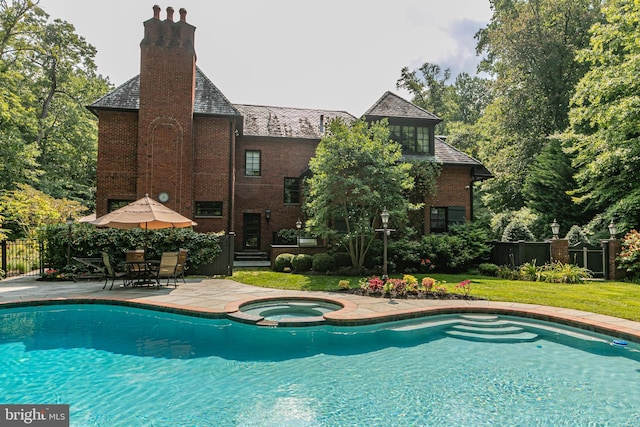 view of pool featuring a yard, a pool with connected hot tub, fence, and a patio