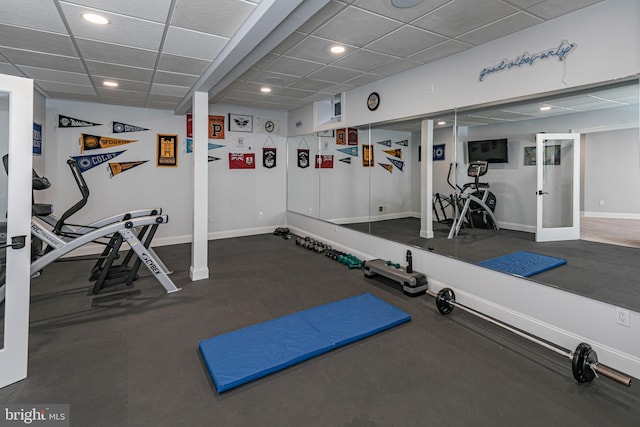 exercise room with recessed lighting, a drop ceiling, and baseboards