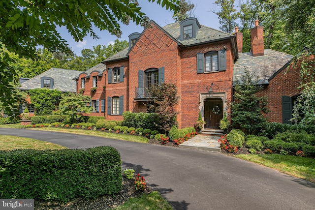 georgian-style home with brick siding and a high end roof