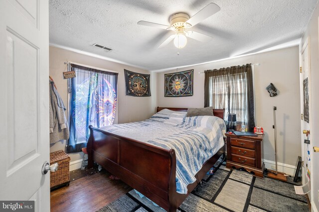 bedroom featuring visible vents, baseboards, dark wood-style floors, ceiling fan, and a textured ceiling