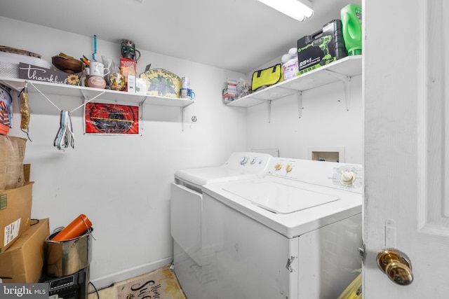 washroom featuring laundry area, washing machine and clothes dryer, and baseboards