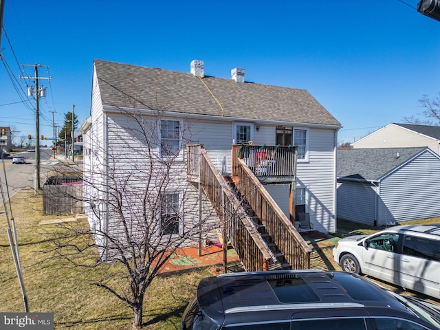 view of front of house with stairs and roof with shingles