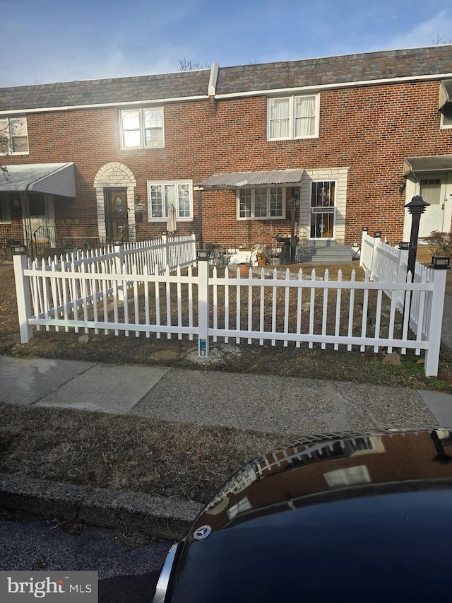 view of property with brick siding and a fenced front yard