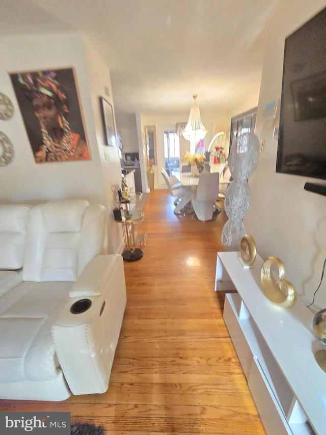 living room with a notable chandelier and wood finished floors