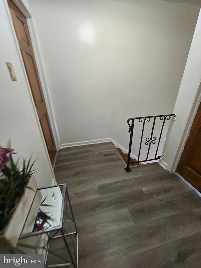 hall with baseboards and dark wood-style flooring