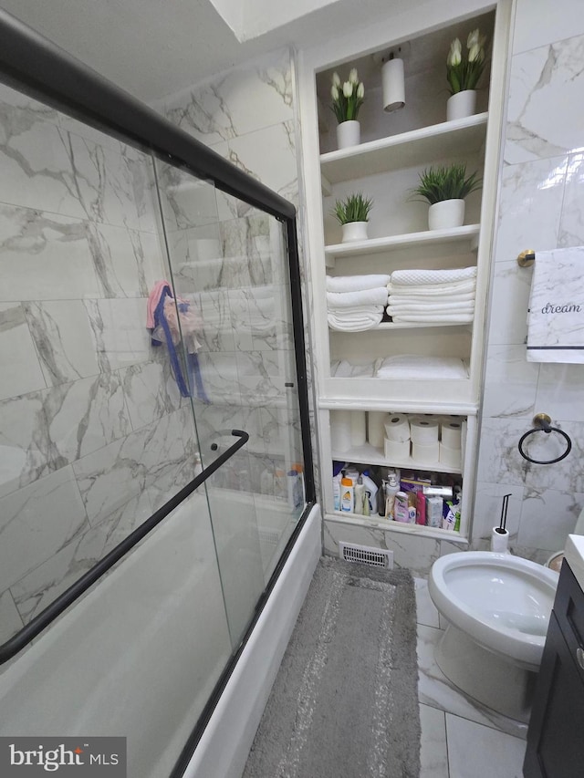 bathroom featuring enclosed tub / shower combo, marble finish floor, and built in shelves