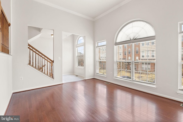 entryway with ornamental molding, wood-type flooring, stairway, and baseboards