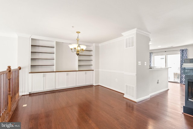 unfurnished dining area featuring visible vents, dark wood-type flooring, and a notable chandelier