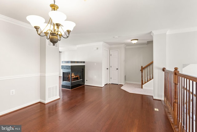 unfurnished living room with visible vents, crown molding, a multi sided fireplace, and wood finished floors