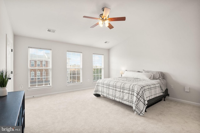 carpeted bedroom featuring multiple windows, visible vents, and baseboards