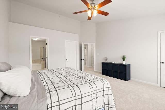 bedroom with carpet floors, vaulted ceiling, ensuite bath, and baseboards