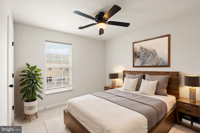 bedroom with light carpet, ceiling fan, and baseboards