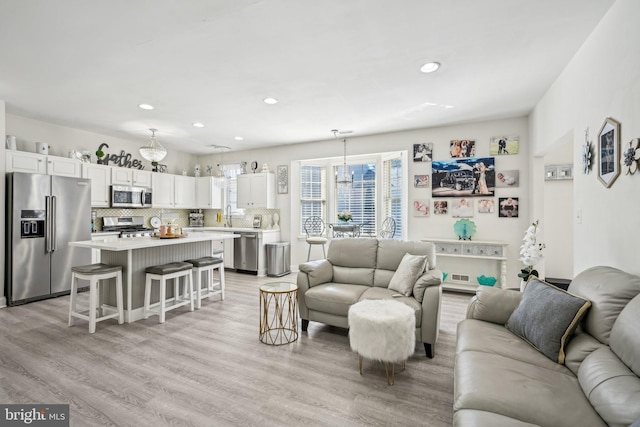 living room featuring light wood-type flooring and recessed lighting