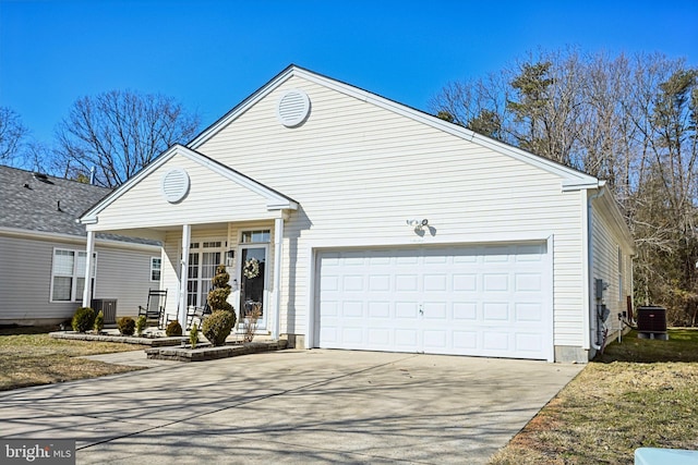 view of front of property with concrete driveway, central AC, and an attached garage