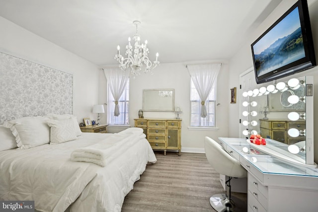 bedroom featuring a notable chandelier, baseboards, and wood finished floors