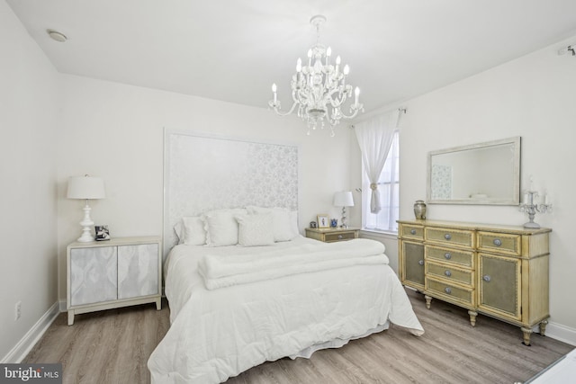 bedroom with an inviting chandelier, wood finished floors, and baseboards