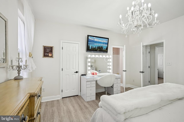 bedroom with light wood-style flooring, baseboards, and an inviting chandelier