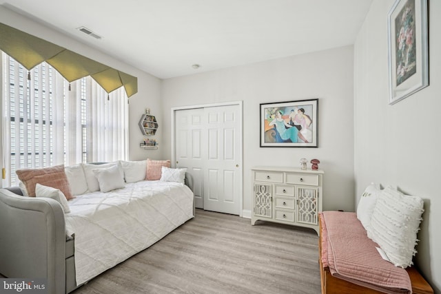 bedroom featuring a closet, wood finished floors, and visible vents