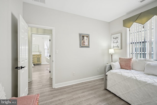 bedroom featuring visible vents, baseboards, and wood finished floors