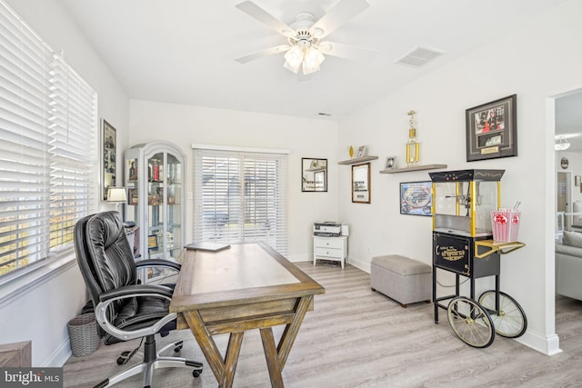 office space with baseboards, ceiling fan, visible vents, and wood finished floors