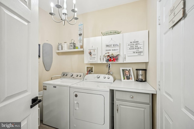 washroom featuring washing machine and dryer, cabinet space, and a notable chandelier