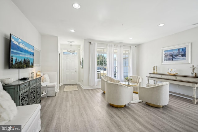 living room with recessed lighting, visible vents, baseboards, and wood finished floors