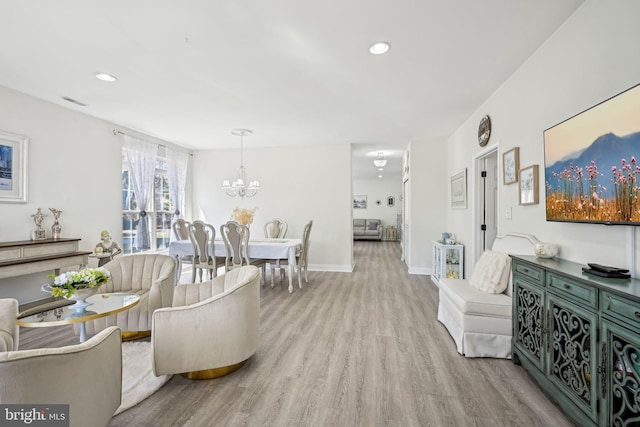 living area with a notable chandelier, baseboards, wood finished floors, and recessed lighting