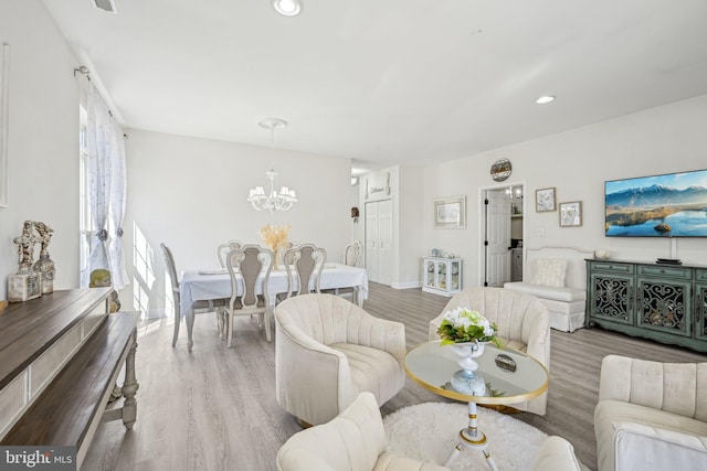 living room featuring a notable chandelier, wood finished floors, and recessed lighting