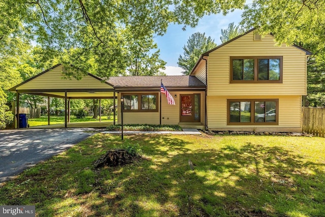 split level home featuring driveway, a front lawn, and fence