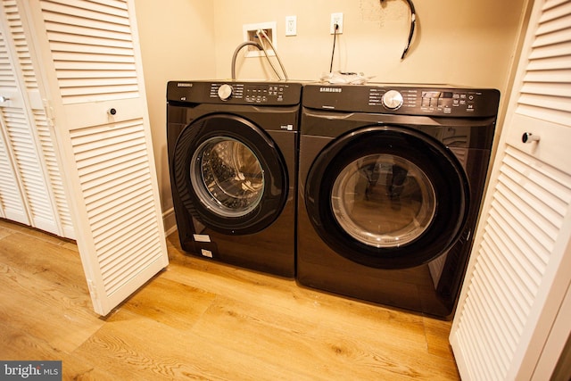 laundry area with light wood-type flooring, laundry area, and independent washer and dryer